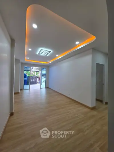Spacious modern living room with stylish ceiling lights and wooden flooring
