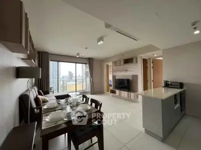 Modern open-plan living and dining area with city view, featuring sleek furniture and contemporary design.