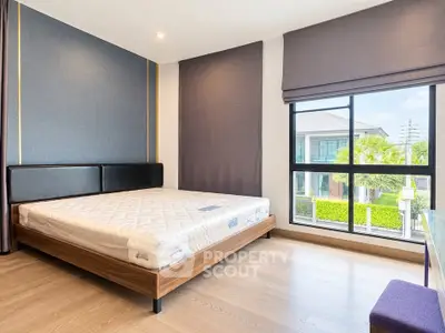 Spacious bedroom with large window and modern decor in a luxury home.
