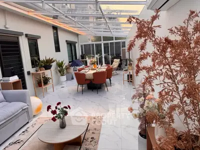 Luxurious sunroom with elegant dining area and modern decor, perfect for entertaining guests.