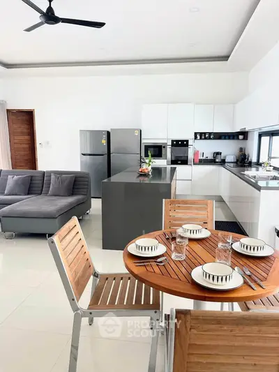 Modern open-plan kitchen and dining area with sleek appliances and stylish furniture