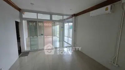 Spacious unfurnished room with large windows and air conditioning, perfect for customization.