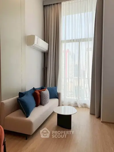 Modern living room with high ceiling, large window, and stylish sofa in a bright apartment.