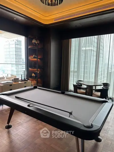 Luxurious living room with pool table and city view, perfect for entertainment and relaxation.
