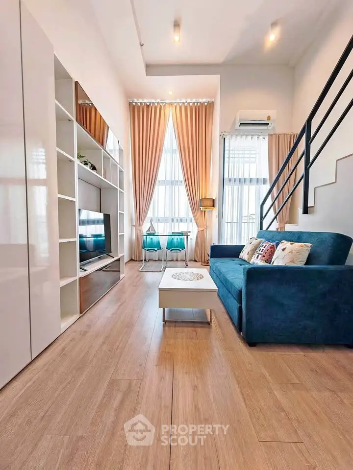 Modern living room with high ceilings, stylish furniture, and large windows for natural light.