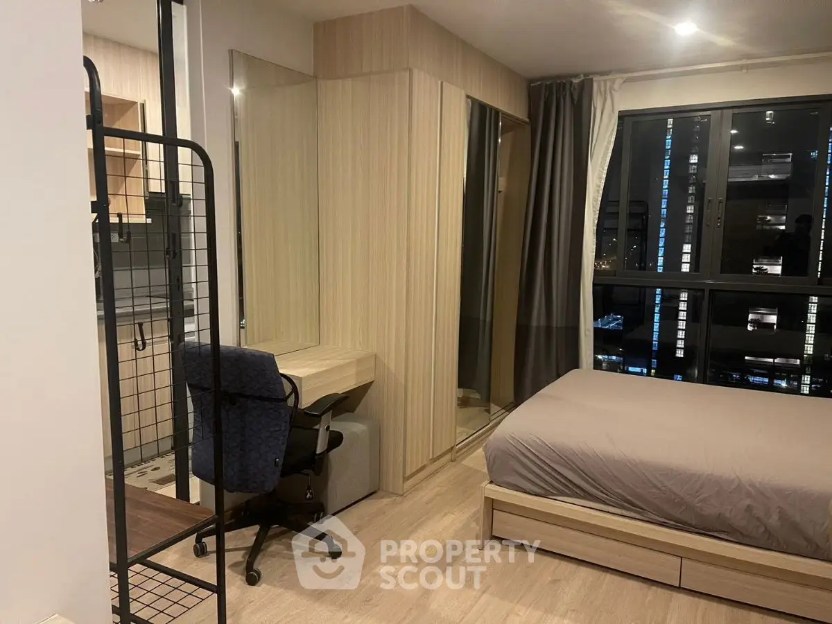 Modern bedroom with study area and large window view in stylish apartment