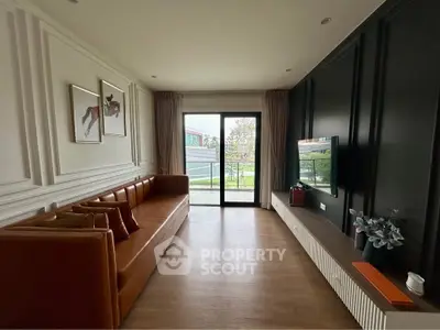 Stylish living room with modern decor and large window offering natural light and garden view.