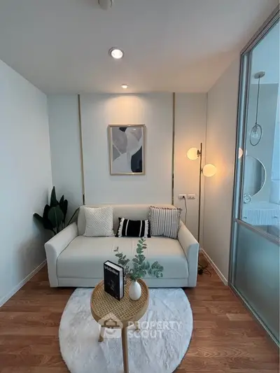 Cozy modern living room with stylish decor and natural light, featuring a comfortable sofa and elegant lighting.