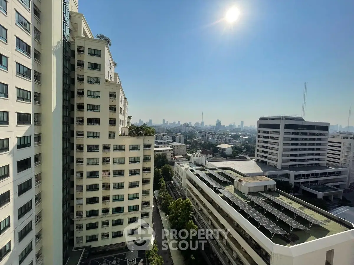 Stunning cityscape view from high-rise building with clear blue sky and bright sunlight.