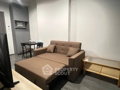 Modern living room with sofa bed and dining area in a stylish apartment.