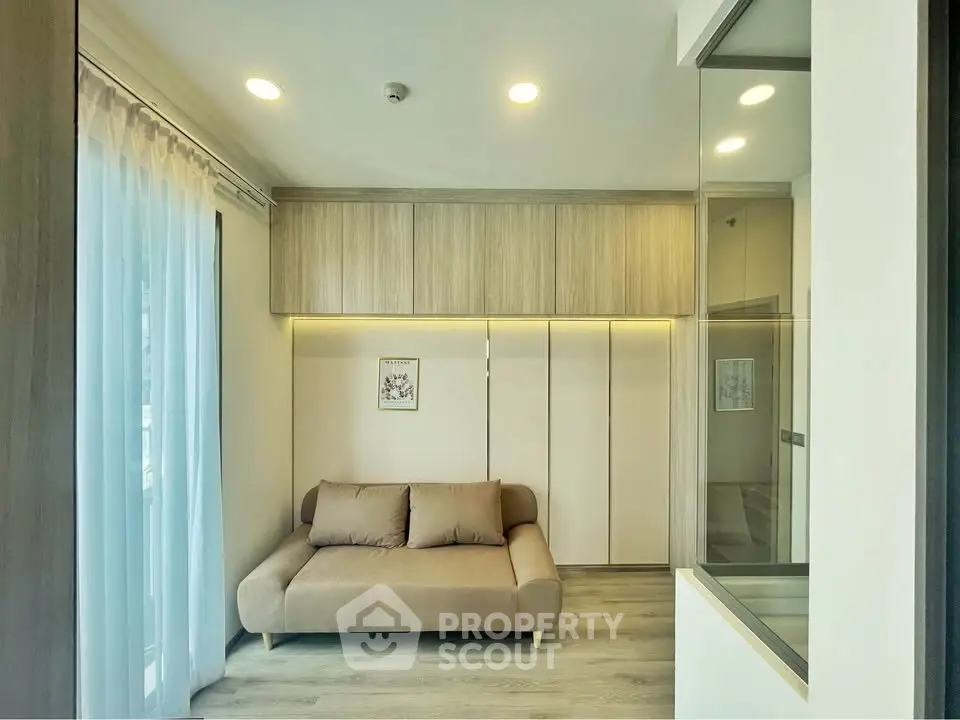 Modern living room with cozy sofa and elegant wooden cabinetry, featuring soft lighting and a serene ambiance.