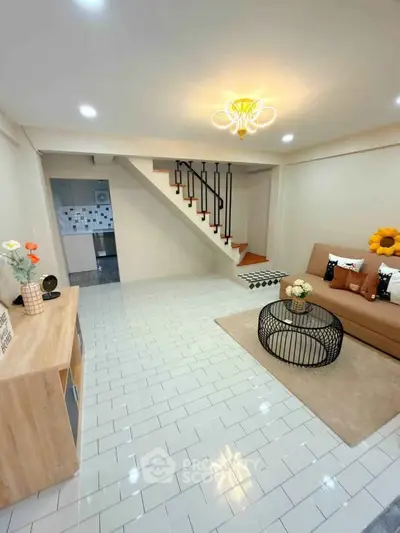 Modern living room with stylish decor and staircase leading to upper floor