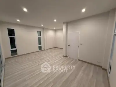 Spacious modern living room with sleek flooring and recessed lighting.