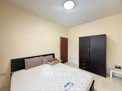 Spacious bedroom with modern furniture and ample natural light.