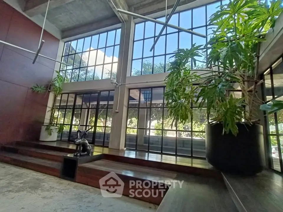 Spacious modern lobby with large windows and lush indoor plants