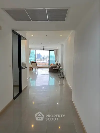Spacious hallway leading to a bright living room with city view