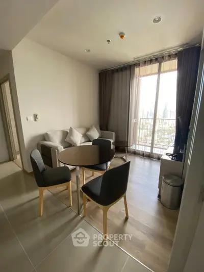 Modern living room with city view, featuring cozy seating and dining area, perfect for urban living.