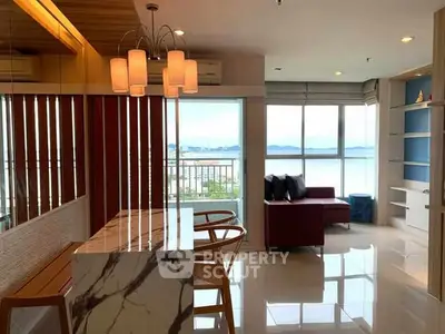 Stylish modern living room with stunning ocean view and elegant marble dining table.