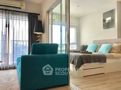 Spacious bedroom with modern decor, large windows, and ample natural light, featuring a cozy bed and stylish teal sofa, perfect for relaxation.