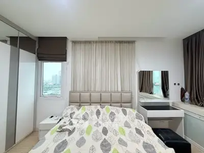 Modern bedroom with stylish decor and city view, featuring a cozy bed and elegant furnishings.