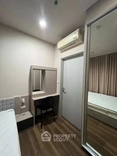Modern bedroom with mirrored wardrobe and air conditioning in stylish apartment.