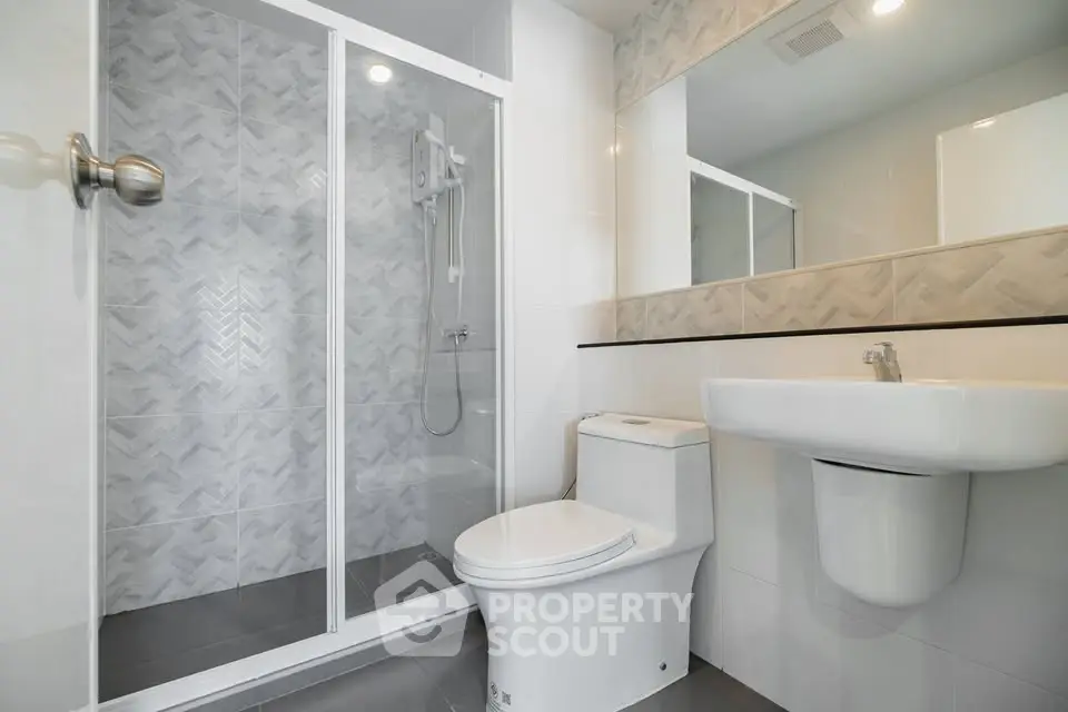 Modern bathroom with sleek shower and contemporary fixtures in a stylish real estate property.