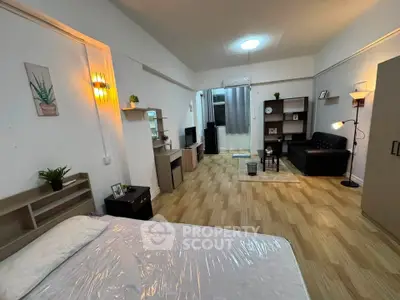 Spacious studio apartment with modern decor and open layout, featuring cozy living area and stylish furnishings.