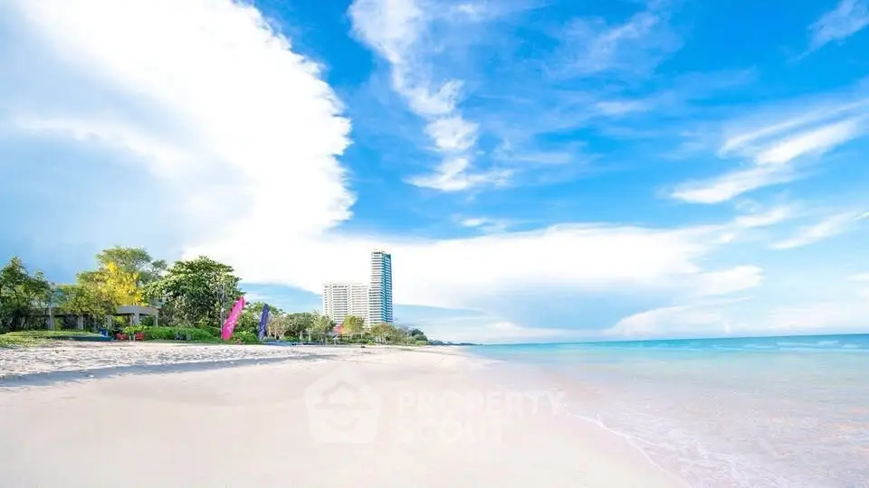 Stunning beachfront view with high-rise building and clear blue skies.