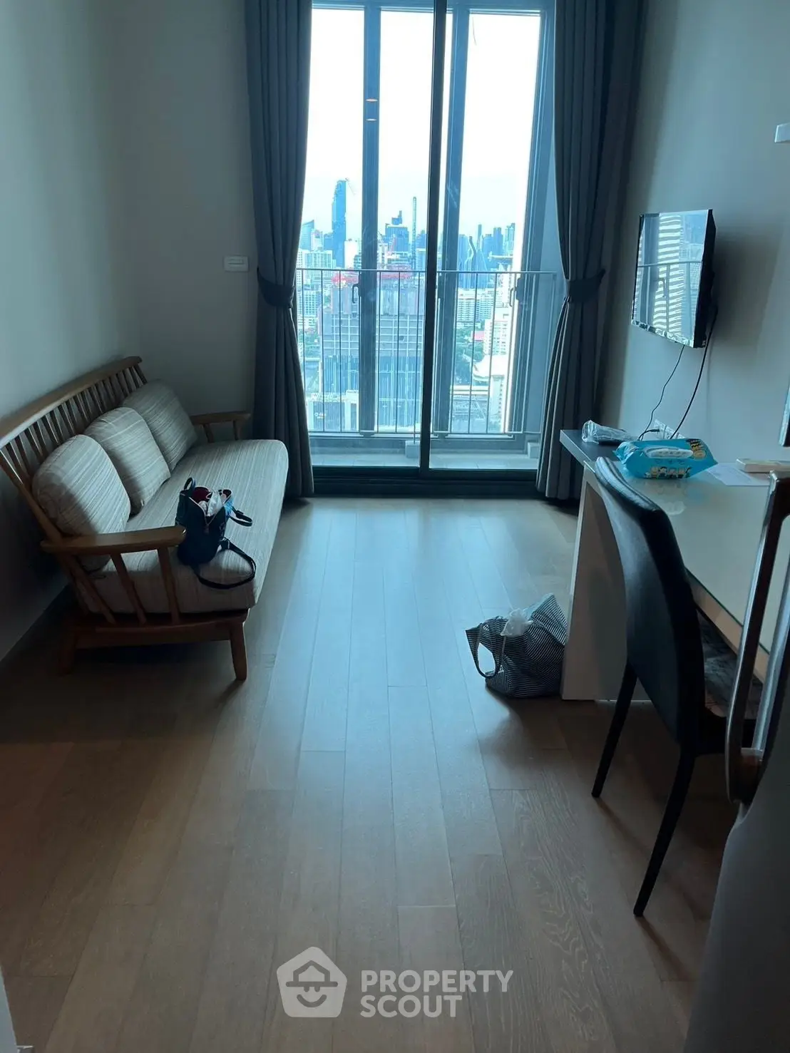 Modern living room with city view, featuring sleek furniture and large windows for natural light.