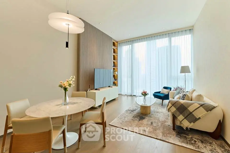 Elegant living room with modern decor, large windows, and stylish furniture in a high-rise apartment.