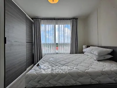 Cozy bedroom with large window and modern wardrobe, offering ample natural light and storage space.