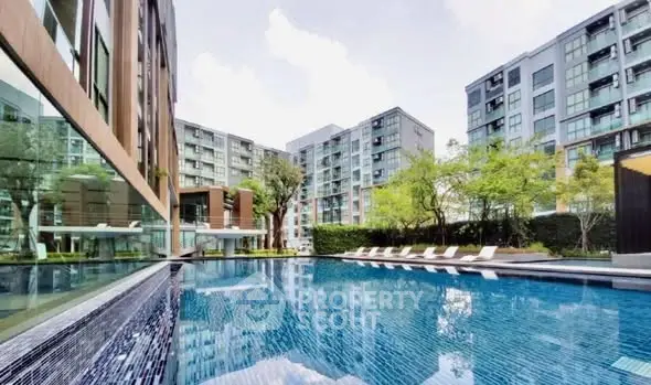 Luxurious modern apartment complex with a stunning outdoor pool and lush greenery.