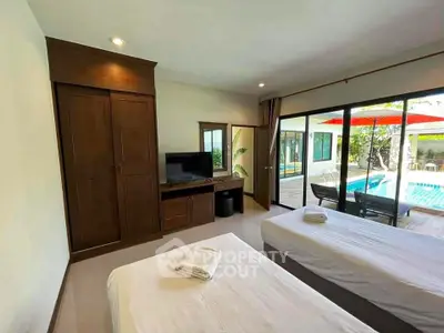Spacious bedroom with pool view and modern amenities in luxury property