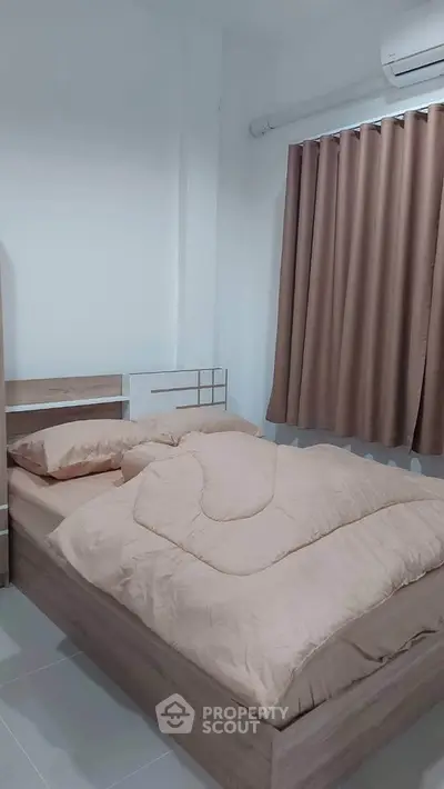 Cozy bedroom with modern decor and neutral tones, featuring a comfortable bed and air conditioning.