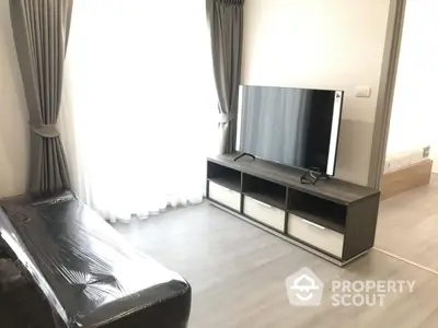 Modern living room with sleek TV stand and large window draped with elegant curtains.