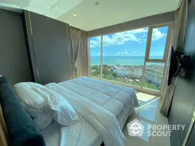 Luxurious bedroom with a panoramic ocean view, featuring a large comfortable bed, sleek design, and natural light flooding in to create a serene ambiance.