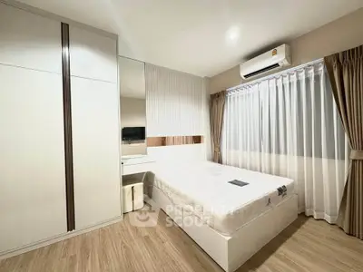 Modern bedroom with stylish decor, featuring a comfortable bed, built-in wardrobe, and large window with curtains.