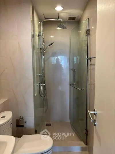 Modern bathroom with glass shower enclosure and sleek fixtures.