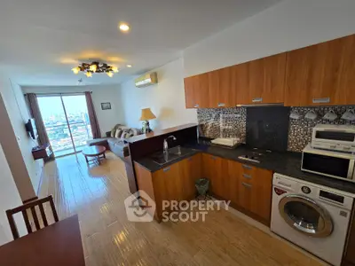 Modern open-layout kitchen and living room with city view, featuring wooden cabinets and appliances.