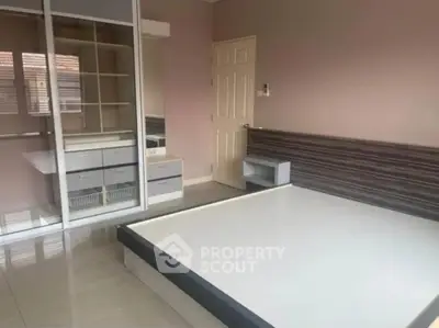 Spacious bedroom with built-in wardrobe and modern design elements.
