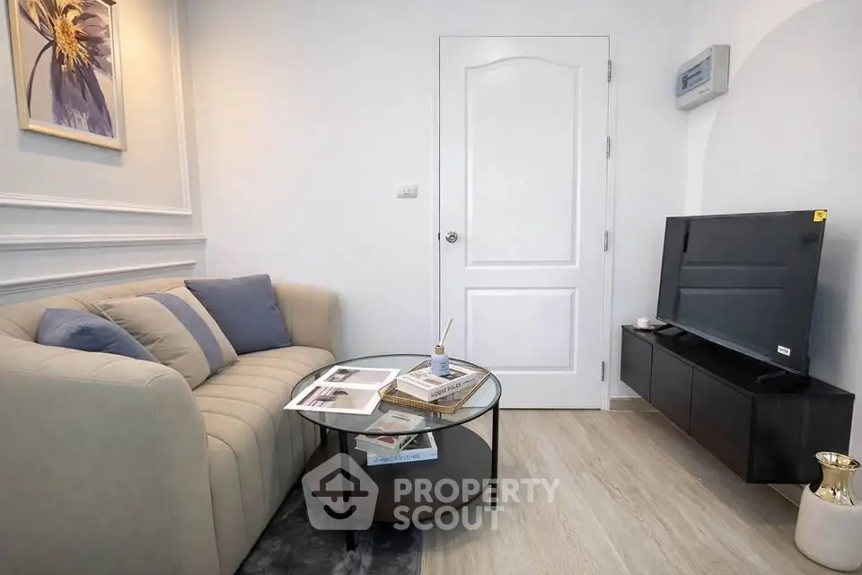 Cozy living room with modern decor and flat-screen TV, perfect for relaxation.