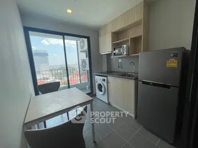 Modern kitchen with balcony view, featuring sleek appliances and compact dining area.