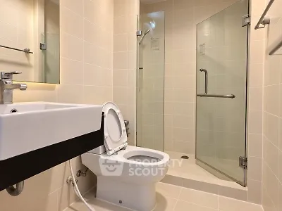 Modern bathroom with glass shower and sleek fixtures in a contemporary apartment.