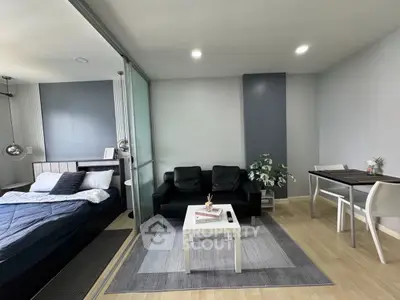 Modern studio apartment with sleek design, featuring a cozy living area and stylish bedroom.
