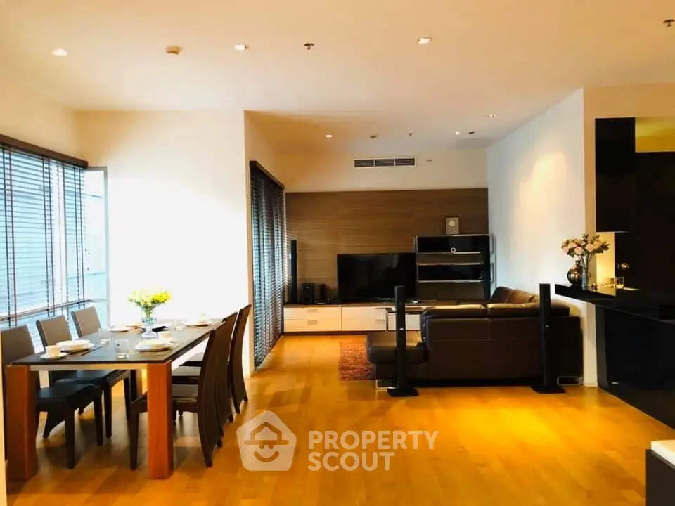 Spacious modern living room with dining area, wooden flooring, and elegant decor.