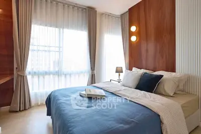 Modern bedroom with stylish decor, large windows, and cozy bedding in a bright apartment.