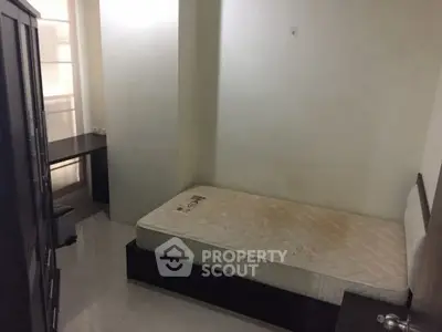 Compact bedroom with single bed and study desk, ideal for minimalist living.