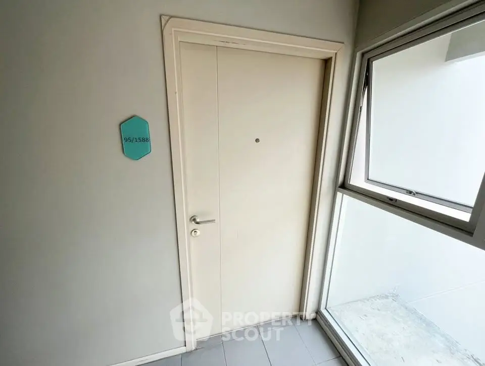 Modern apartment entrance with sleek door and window, showcasing minimalist design.
