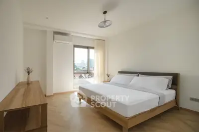 Spacious modern bedroom with large window and minimalist decor