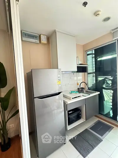 Modern compact kitchen with sleek appliances and balcony access